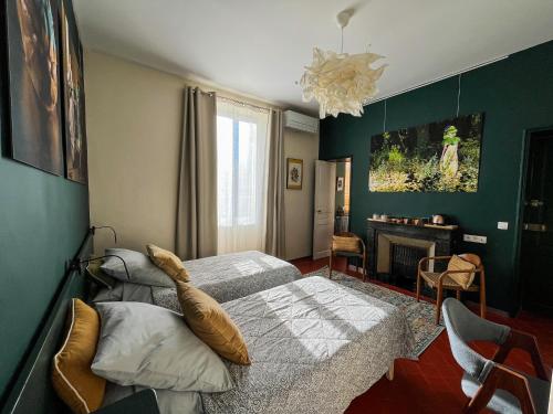 a bedroom with two twin beds and a fireplace at La maison Gerval in Bédoin