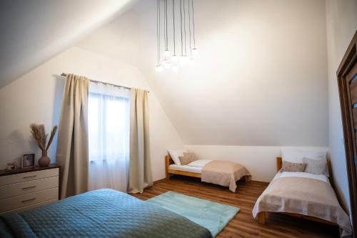 a bedroom with two beds and a window at Apartmánový dom Budiná in Budiná