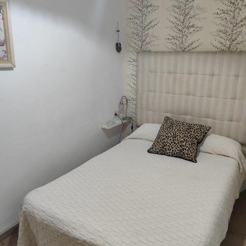 a bedroom with a bed with a cheetah pillow on it at CENTRO HISTORICO in Manzanares