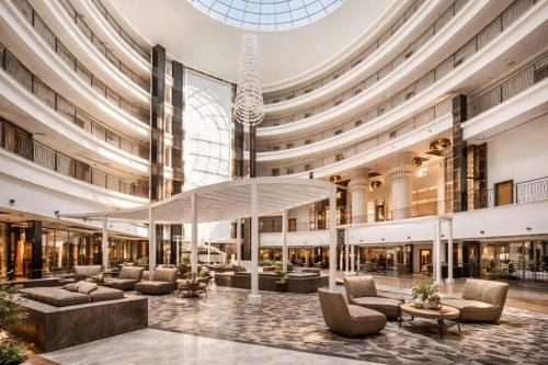 a large lobby with couches and tables in a building at Alodger Sirius Town Lara in Aksu