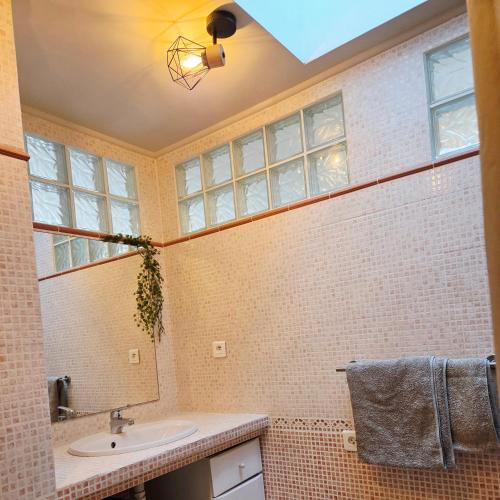 un bagno con lavandino e specchio di Le HERON a Arles