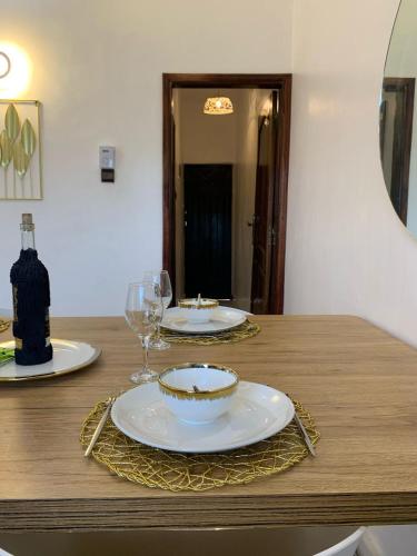 a table with two plates and glasses on it at 2 chambres salon au calme in Porto-Novo