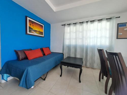 a blue room with a bed and a table at Apartamentos Sound Bay Beach in San Andrés
