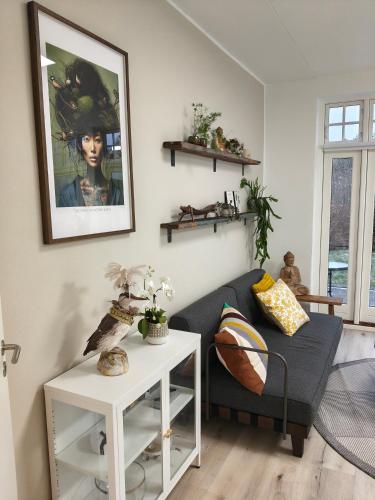 a living room with a couch and a painting on the wall at Eksklusiv villalejlighed m/ have in Holme
