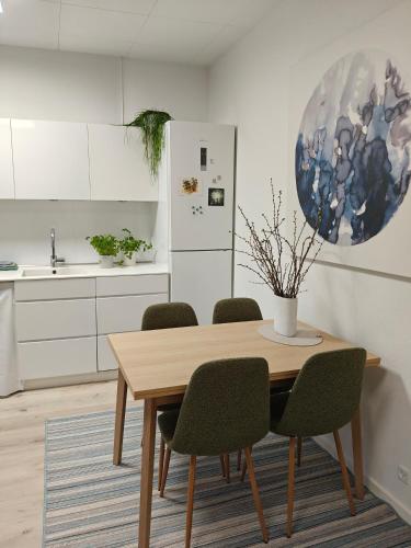 a kitchen with a wooden table and green chairs at Eksklusiv villalejlighed m/ have in Holme