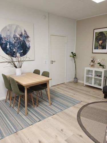 a dining room with a wooden table and chairs at Eksklusiv villalejlighed m/ have in Holme