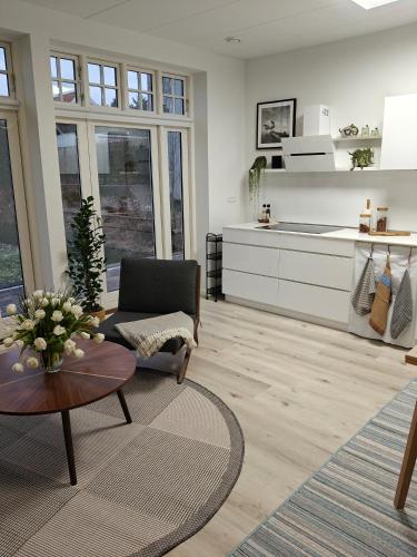 a living room with a table and a kitchen at Eksklusiv villalejlighed m/ have in Holme