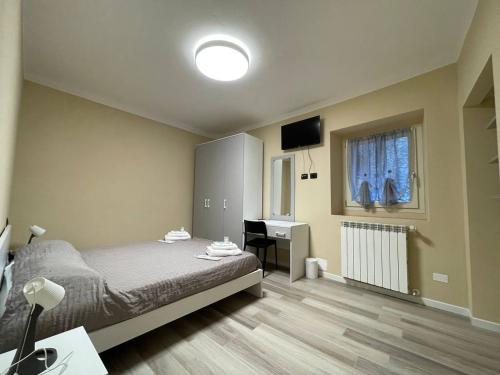 ein Schlafzimmer mit Bett, Schreibtisch und Fenster in der Unterkunft Casa Alone in Casto