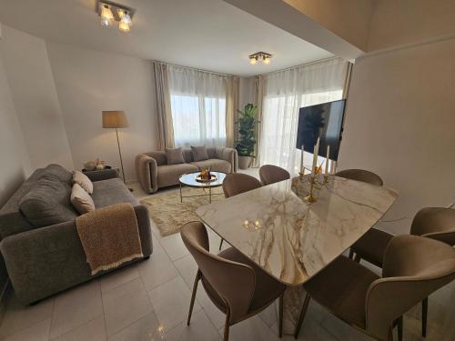 a living room with a table and a couch at Beach Front View Apartment Sea Pool & Prime Location in Limassol