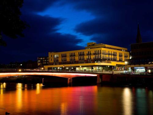 a bridge over a river in a city at night at 208 By The Bridge Apartment in Inverness