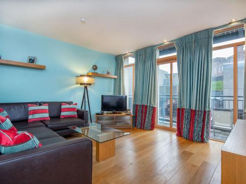 a living room with a couch and a tv at 208 By The Bridge Apartment in Inverness