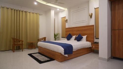a bedroom with a large bed and a table and chair at Ramjay Corbet Jungle Resort in Kotdwāra