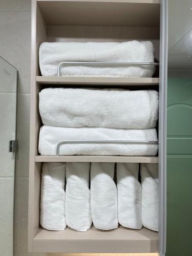 a stack of towels in a closet at Mapo Panorama Stay in Seoul