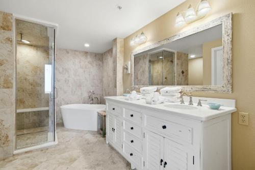 a bathroom with a sink and a tub and a mirror at Spanish Key 209 in Perdido Key