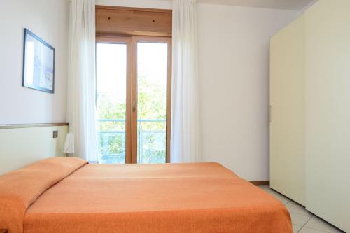 a bedroom with a bed with a large window at Sunbeach Apartments in Lignano Sabbiadoro