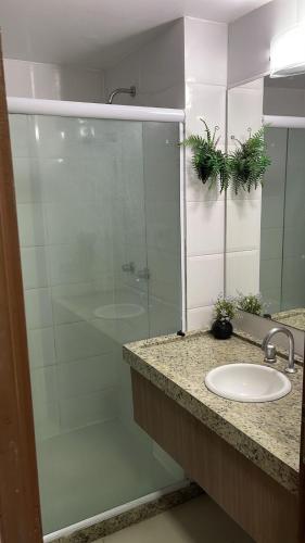 a bathroom with a glass shower and a sink at Nobile Imperial Flat in João Pessoa
