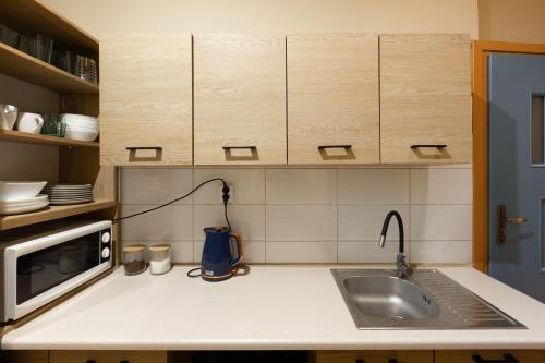 a kitchen with a sink and a microwave at WOW Hostel in Krakow