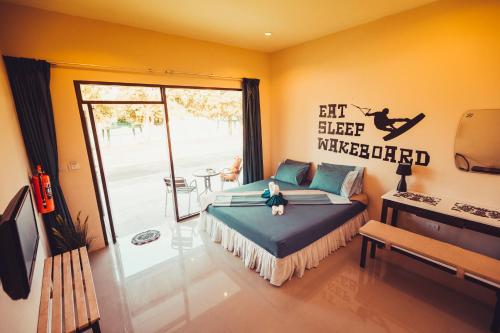 a bedroom with a bed and a sliding glass door at Phuket Wake Park in Kathu