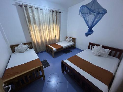 a room with two beds and a window at LOTUS HOLIDAY REST in Anuradhapura