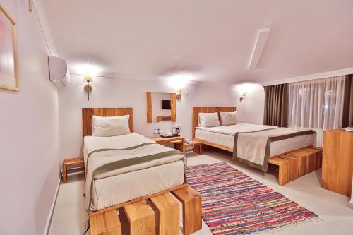 a hotel room with two beds and a television at Livadi Jur in Akçakoca