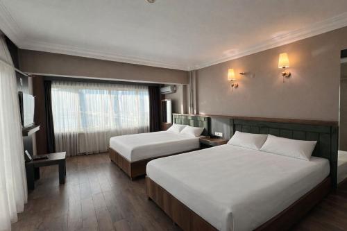 a hotel room with two beds and a window at Samsun Airport Resort Hotel in Samsun