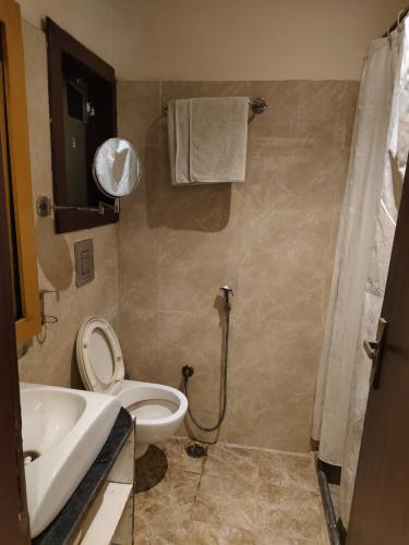 a bathroom with a toilet and a sink and a shower at Hotel The Rajputana Ranthambore in Sawāi Mādhopur