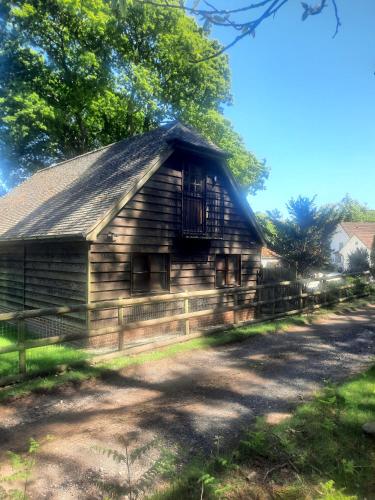 an old wooden barn with a roof at The Barn at Creech View in Wareham