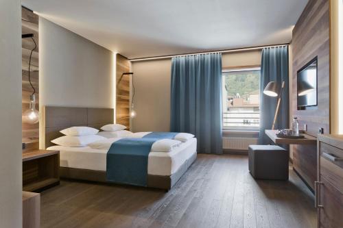 a hotel room with a bed and a window at Stadthotel Brunner in Schladming