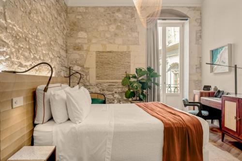 a bedroom with a white bed and a piano at COOL DREAMS Luxury Rooms in Syracuse