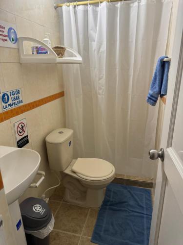 a bathroom with a toilet and a shower curtain at Apartamentos Sound Bay Beach in San Andrés