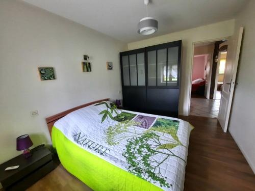 a bedroom with a bed with a green comforter at Gîte de Maurin campagne in Marguestau