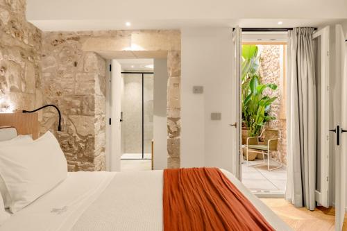 a bedroom with a bed and a stone wall at COOL DREAMS Luxury Rooms in Syracuse