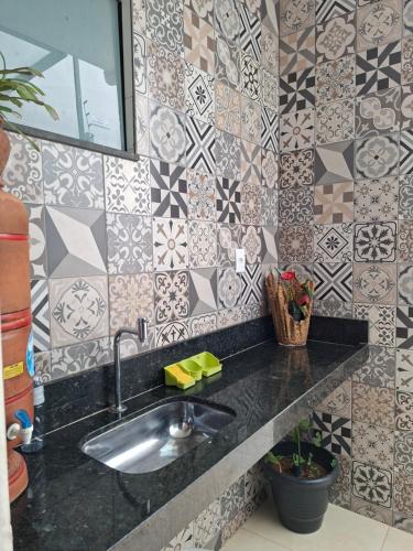 a bathroom with a sink and a tiled wall at Casa Tranquila em Diamantina in Diamantina