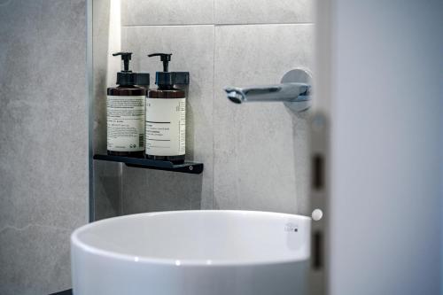 a bathroom with two bottles of soap and a sink at Helichrysum Lofts Junior House J1 in Khokhlastí