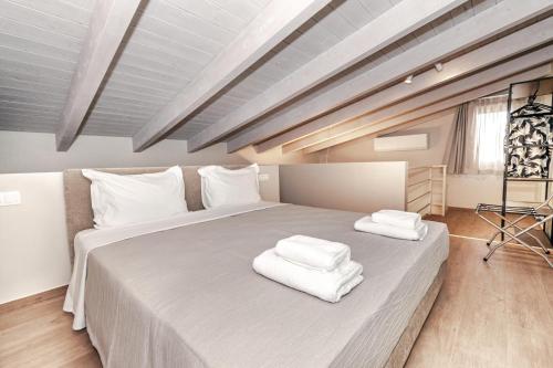 a bedroom with a large bed with towels on it at Helichrysum Lofts Junior House J1 in Khokhlastí