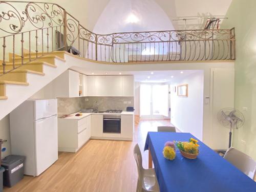 a kitchen with a blue table and a staircase at Corso Suite Gallipoli in Gallipoli
