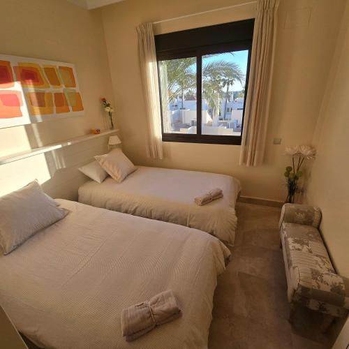two beds in a room with a window at Paraíso de Roda Golf in Roda