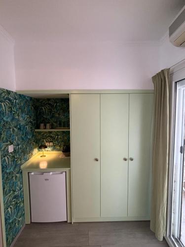 a bathroom with a sink and a cabinet at T H E BERLIN Studios and Suites in Nea Vrasna