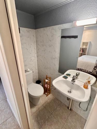 a bathroom with a sink and a toilet and a bed at Beaurivage, studio privé dans maison d'hôte avec parc in Libourne