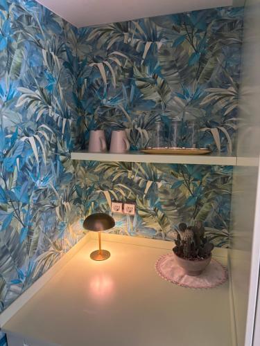 a shelf with a lamp and a plant on a wall at T H E BERLIN Studios and Suites in Nea Vrasna