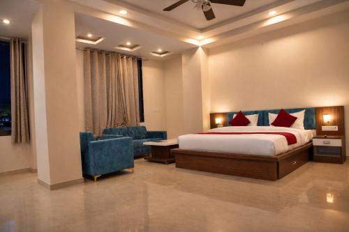 a hotel room with a bed and a blue chair at Hotel Jaipur Shertone in Jaipur