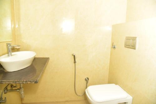 a bathroom with a white toilet and a sink at Hotel Jaipur Shertone in Jaipur