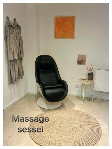 a black chair sitting in a room with a rug at Home Ida in Klotten