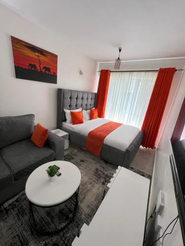 a bedroom with a bed and a couch and a table at Tusmo homes in Ongata Rongai 