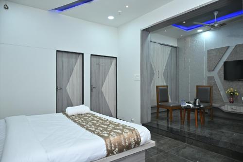 a bedroom with a bed and a table and a tv at Hotel Shree Niwas Inn Near Airport in Jāmb