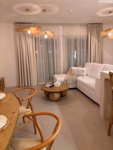 a living room with a white couch and a table at Dubai Escape Private Pool and Parking in Dubai
