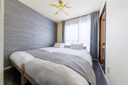 a bedroom with a large bed and a window at Maison Odori-Higashi building in Sapporo