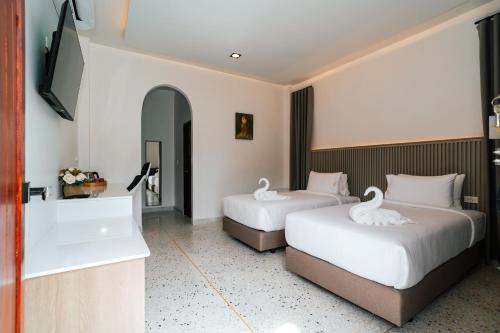 a hotel room with two beds and a bathtub at on and on haus in Ban Na Nian