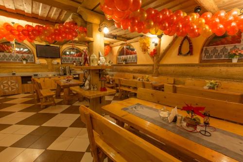 a restaurant with wooden tables and balloons hanging from the ceiling at Tatrzański Dworek in Biały Dunajec