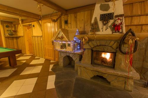 a living room with a fireplace and a pool table at Tatrzański Dworek in Biały Dunajec